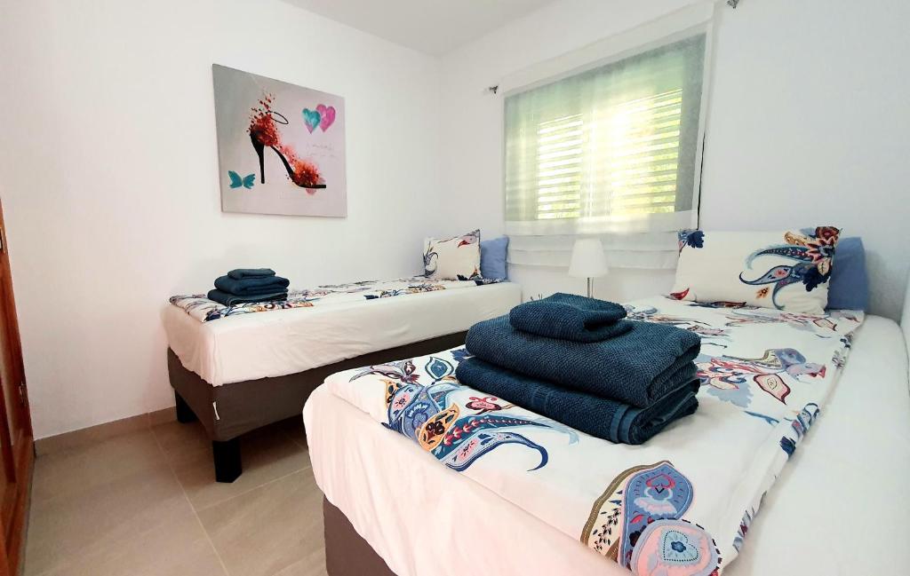 sypialnia z dwoma łóżkami i ręcznikami na górze w obiekcie Mint Apartment w mieście San Bartolomé