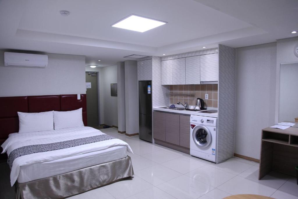 a bedroom with a bed and a washing machine at J Hotel in Ulaanbaatar