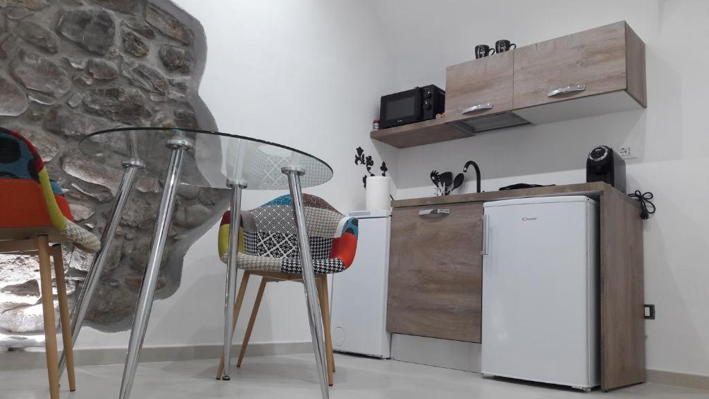 eine Küche mit einem Glastisch und einem Kühlschrank in der Unterkunft C'era una volta (suite) in Isolabona