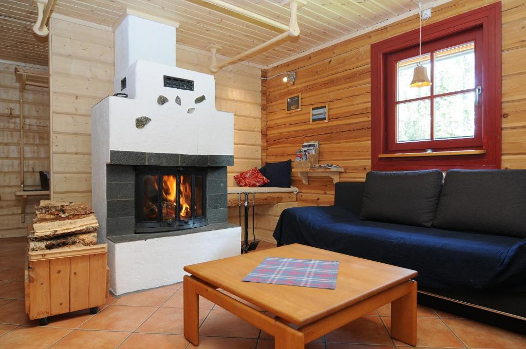 a living room with a fireplace in a log cabin at Galå Fjällgård in Galåbodarna