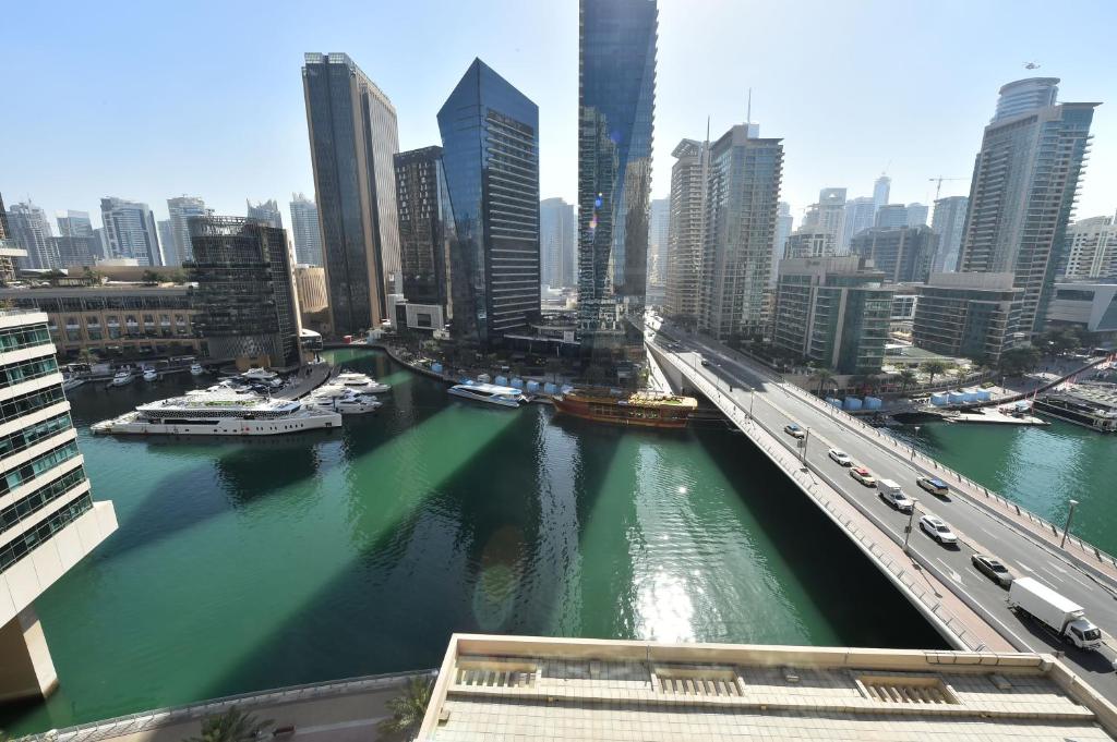 un puente sobre un río con barcos en una ciudad en 2-BR Marina View Retreat at Marina Quays - DSY, en Dubái