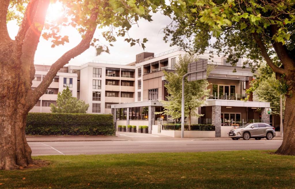 un bâtiment avec une voiture garée devant lui dans l'établissement Rydges Latimer Christchurch, à Christchurch