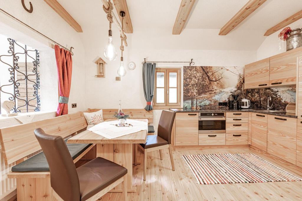 cocina con armarios de madera y mesa de madera en Ferienhaus Spitzenhof - Urlaub am Bauernhof en Mooslandl