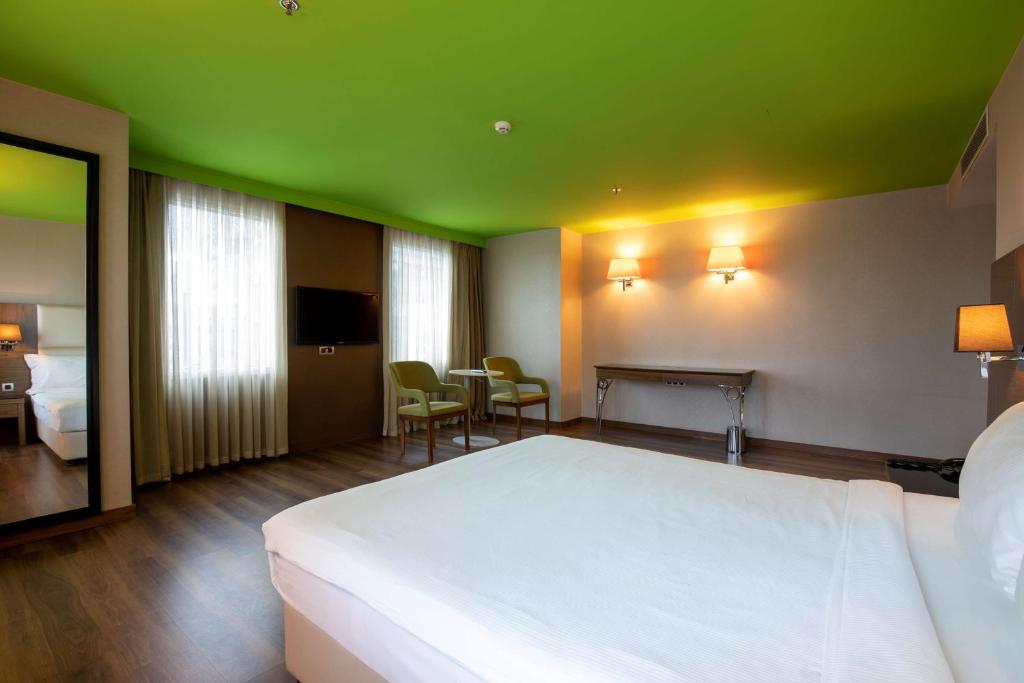 a bedroom with a white bed and a green ceiling at Park Inn by Radisson Istanbul Asia Kavacik in Istanbul