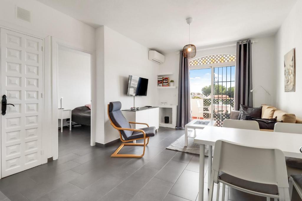een woonkamer met een tafel en stoelen en een bank bij 1 bedroom in Verano Azul, Free Wi-fi in Nerja