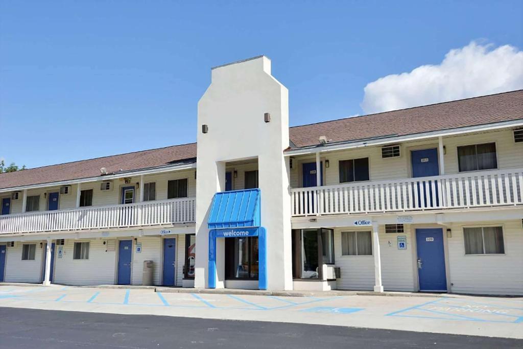 a large white building with blue doors on a street at Travelodge by Wyndham Brattleboro VT in Brattleboro