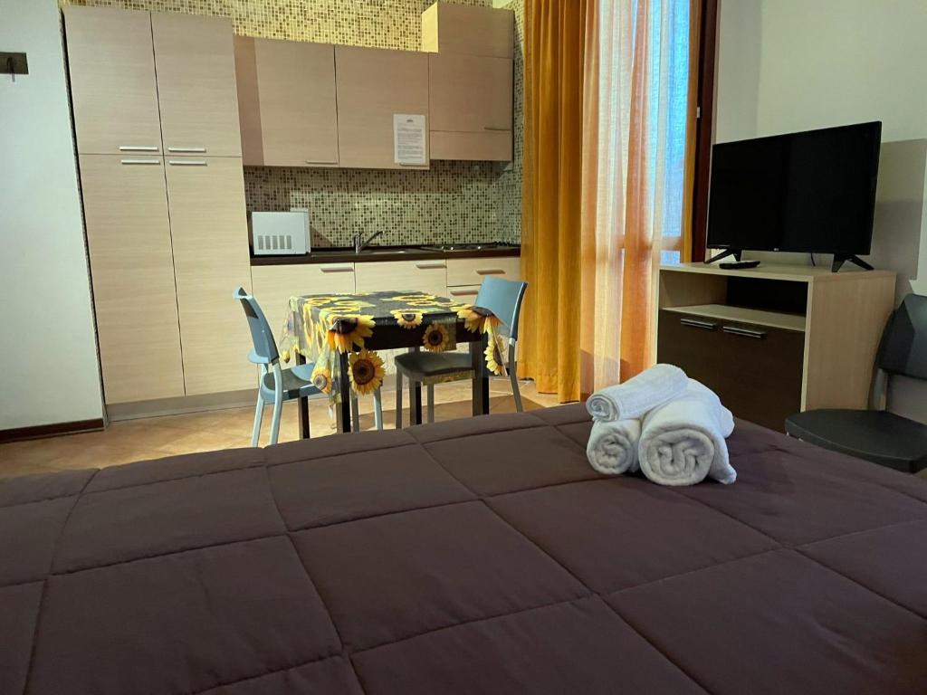 a bedroom with a bed with a table and a kitchen at Residence Cimone SuperSci in Riolunato