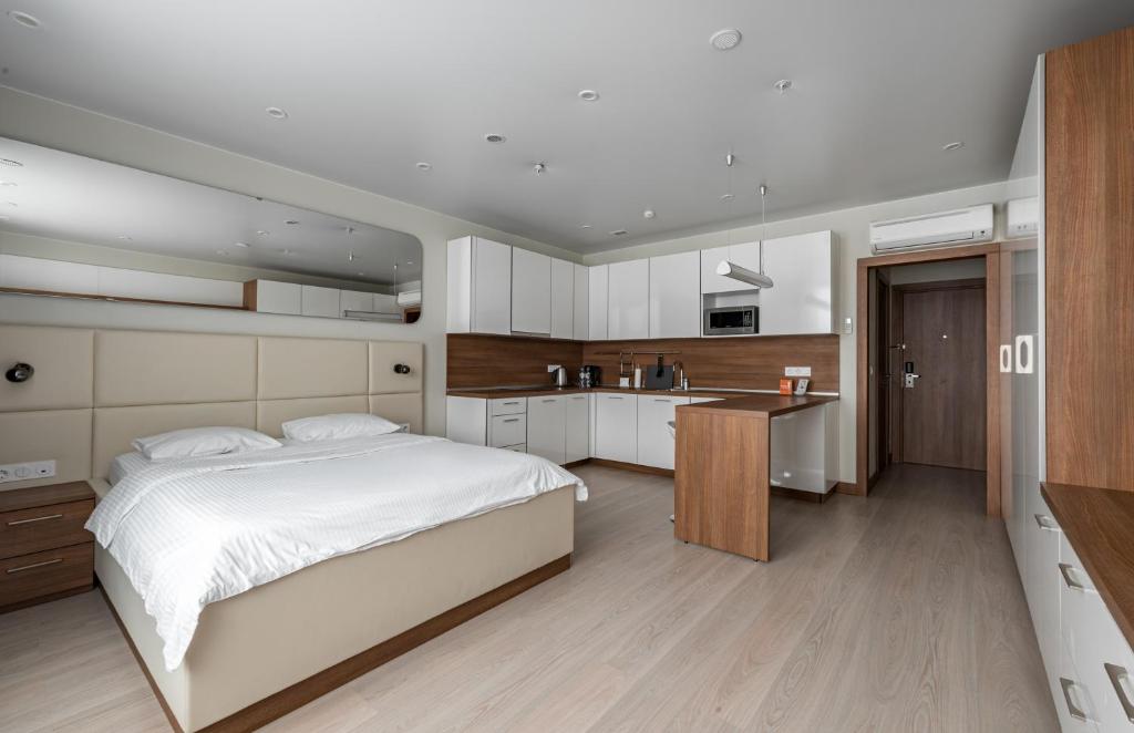 1 dormitorio con 1 cama blanca grande y cocina en Апарт-отель YE'S Mitino, en Moscú
