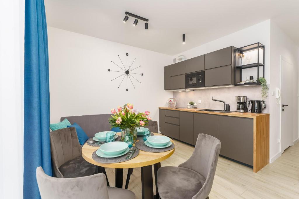 a kitchen and dining room with a table and chairs at Sunset Resort - Apartament Florencja in Grzybowo