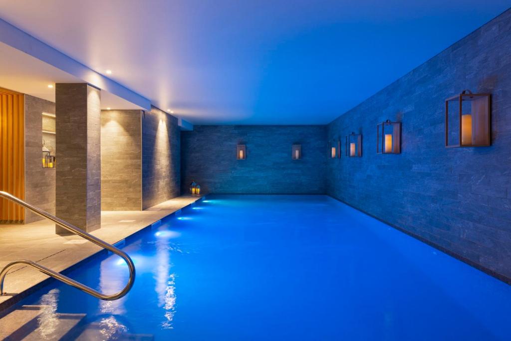 ein Pool mit blauen Lichtern in einem Gebäude in der Unterkunft RockyPop Flaine Hotel & Spa in Flaine