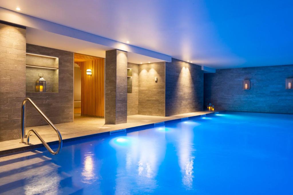 a swimming pool in a hotel with blue lighting at RockyPop Flaine Hotel & Spa in Flaine