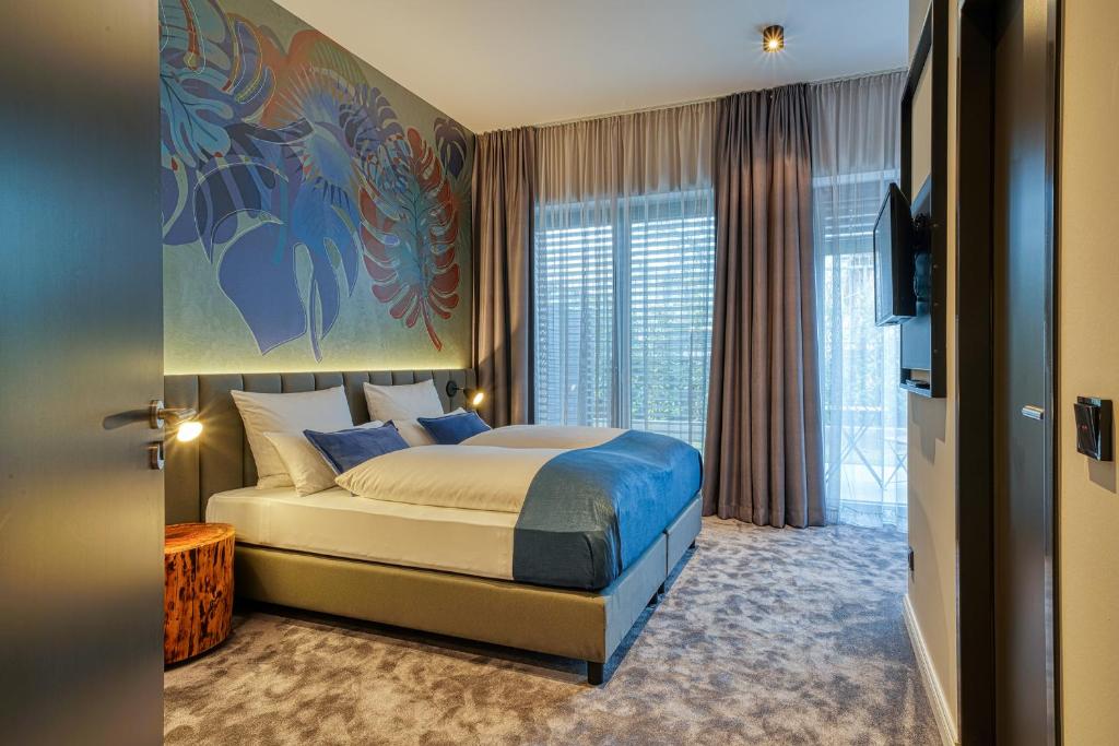 a bedroom with a king sized bed and a tv at NYCE Hotel Bonn in Bonn