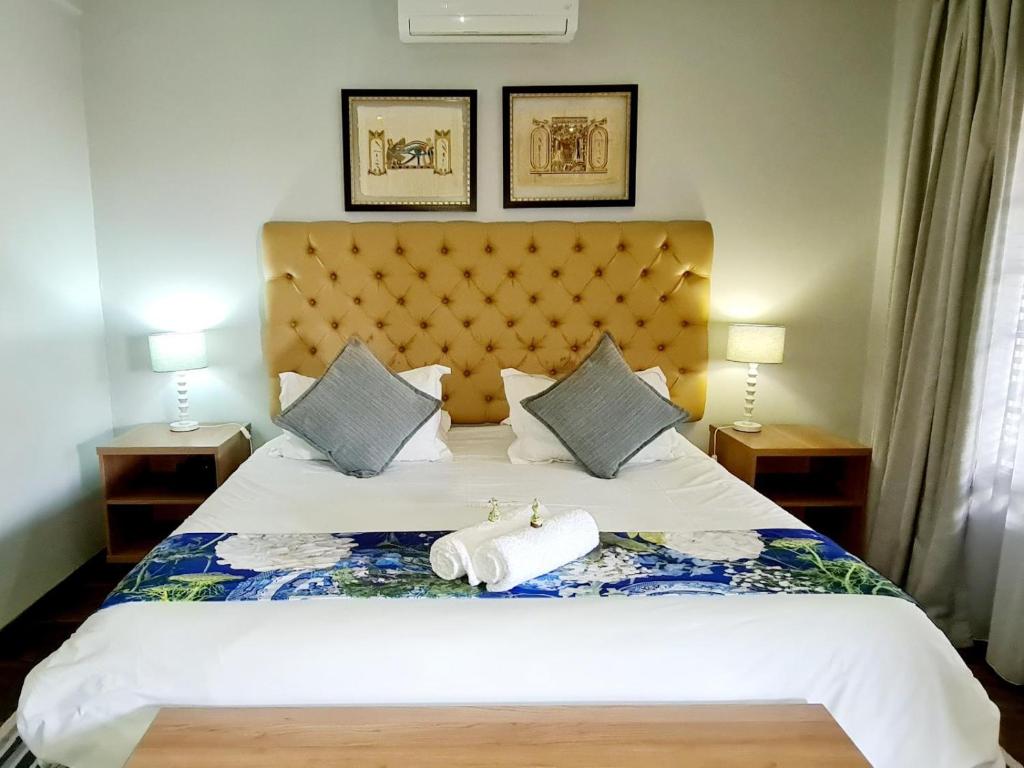 1 dormitorio con 1 cama con 2 toallas en Magalies Mountain Lodge and Spa, en Hartbeespoort