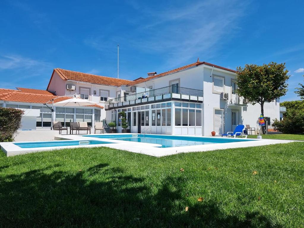 a large house with a swimming pool in the yard at Hotel Solar das Laranjeiras in Vale de Cambra
