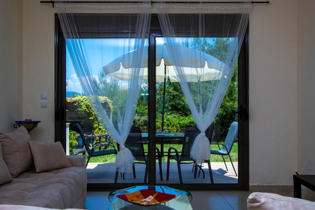a living room with a couch and a large glass window at Possidi Villas by Halkidiki Villas in Possidi