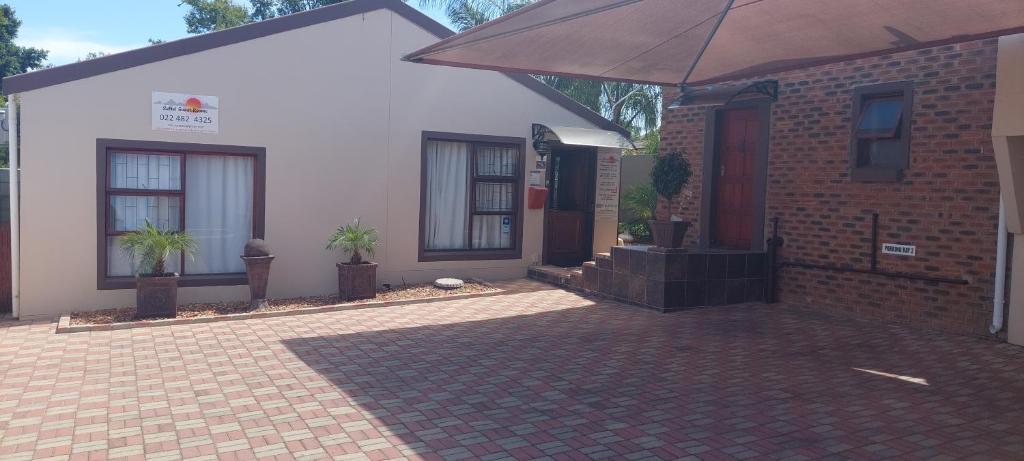 a house with an umbrella in front of it at SuNel's Guest Rooms in Malmesbury