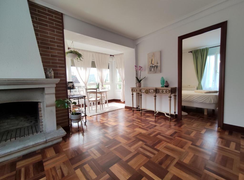 - un salon avec une cheminée et un miroir dans l'établissement Apartamento Lurra Barrika, à Barrika