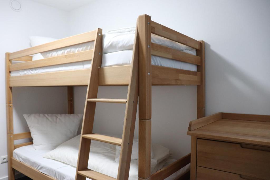 a bunk bed with a ladder next to a desk at Ferienwohnung Treibholz in Binz