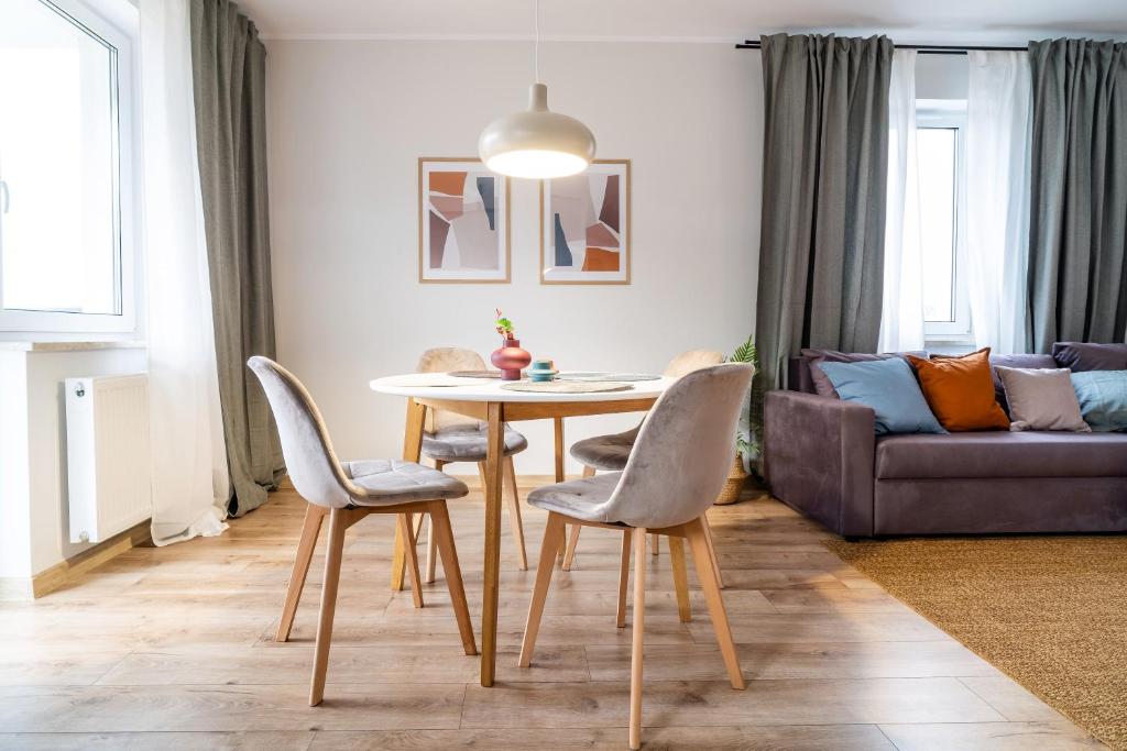 a living room with a table and chairs and a couch at Central Apartment in Iława
