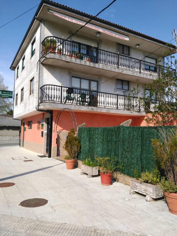 a building with a balcony with plants on it at Vilariño Moscoso in Arzúa
