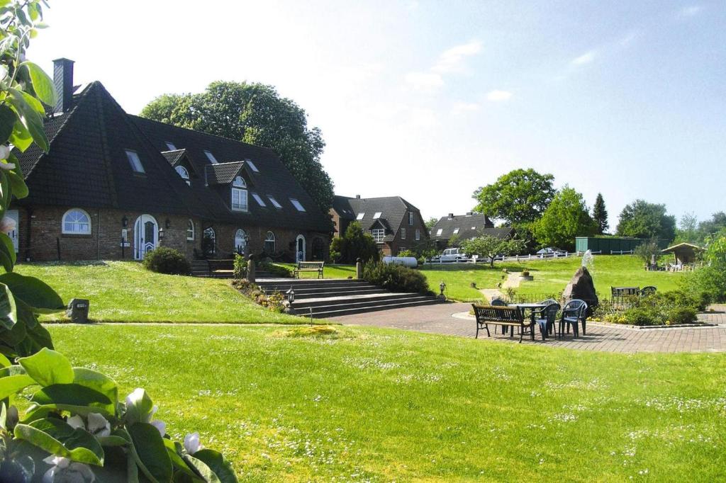 a house on a green lawn with tables and chairs at Ferienwohnanlage Gut Bundhorst, Stolpe in Stolpe