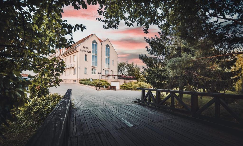 a wooden bridge leading to a large building at Hotel Lajta Park in Mosonmagyar&oacute;v&aacute;r