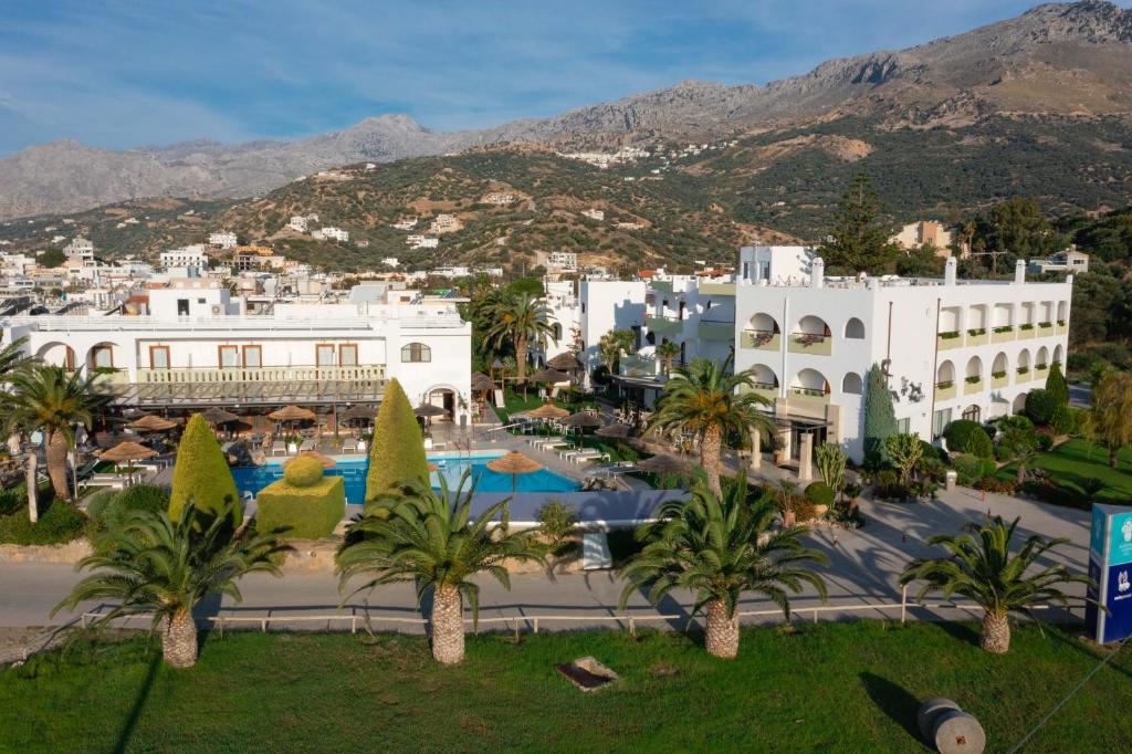 een uitzicht op een resort met palmbomen en gebouwen bij Alianthos Garden in Plakias