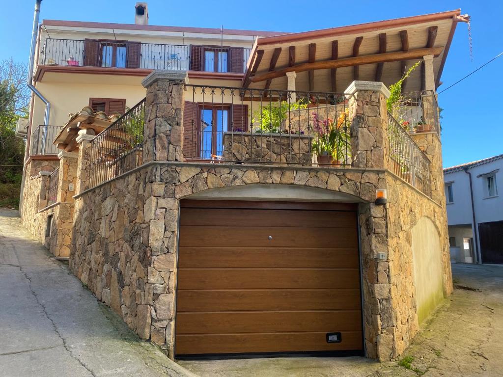 a building with a garage door with a balcony at Il pergolato in Bari Sardo