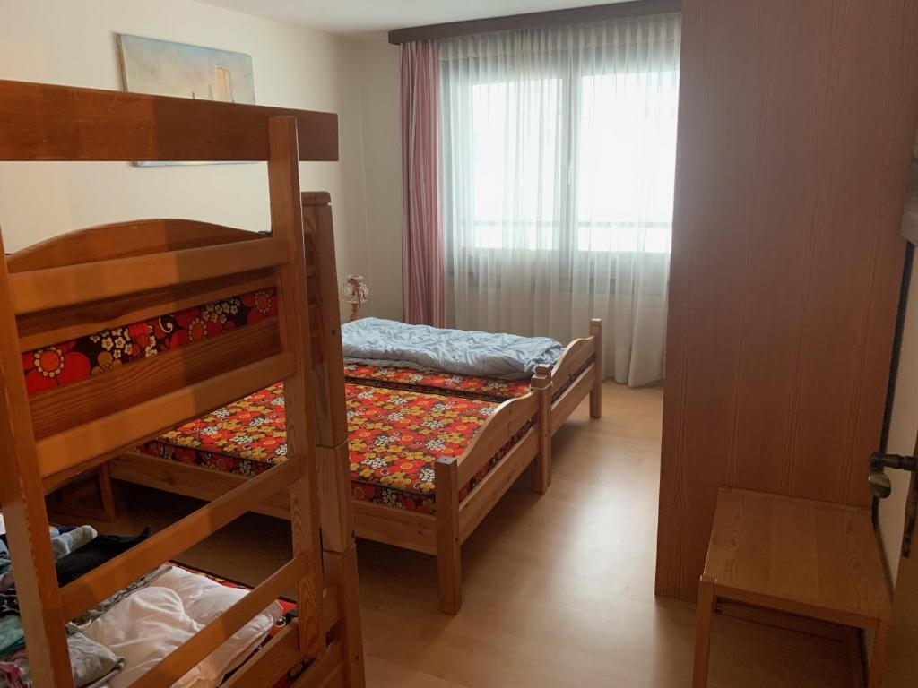 1 Schlafzimmer mit 2 Etagenbetten und einem Fenster in der Unterkunft Casa Surselva Whg Bilger in Savognin