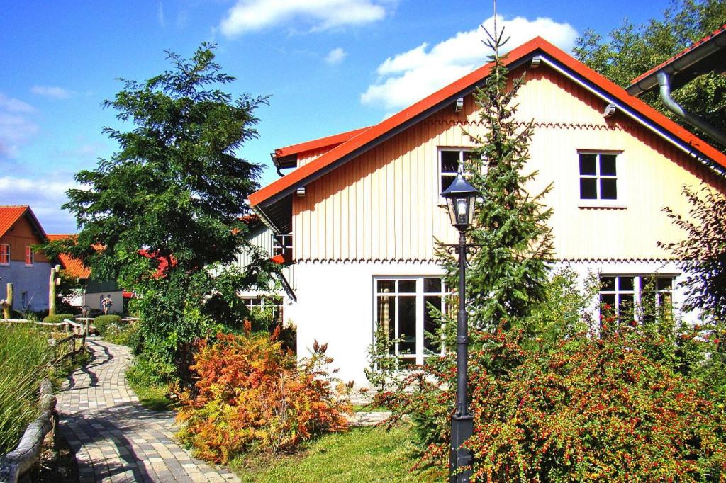 a white house with an orange roof and a street light at Ferienhaus in Wernigerode mit Innenpool in Wernigerode