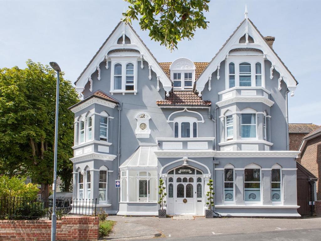 duży niebieski dom z białym przycinaniem w obiekcie Oaklands Guest House w mieście Weymouth
