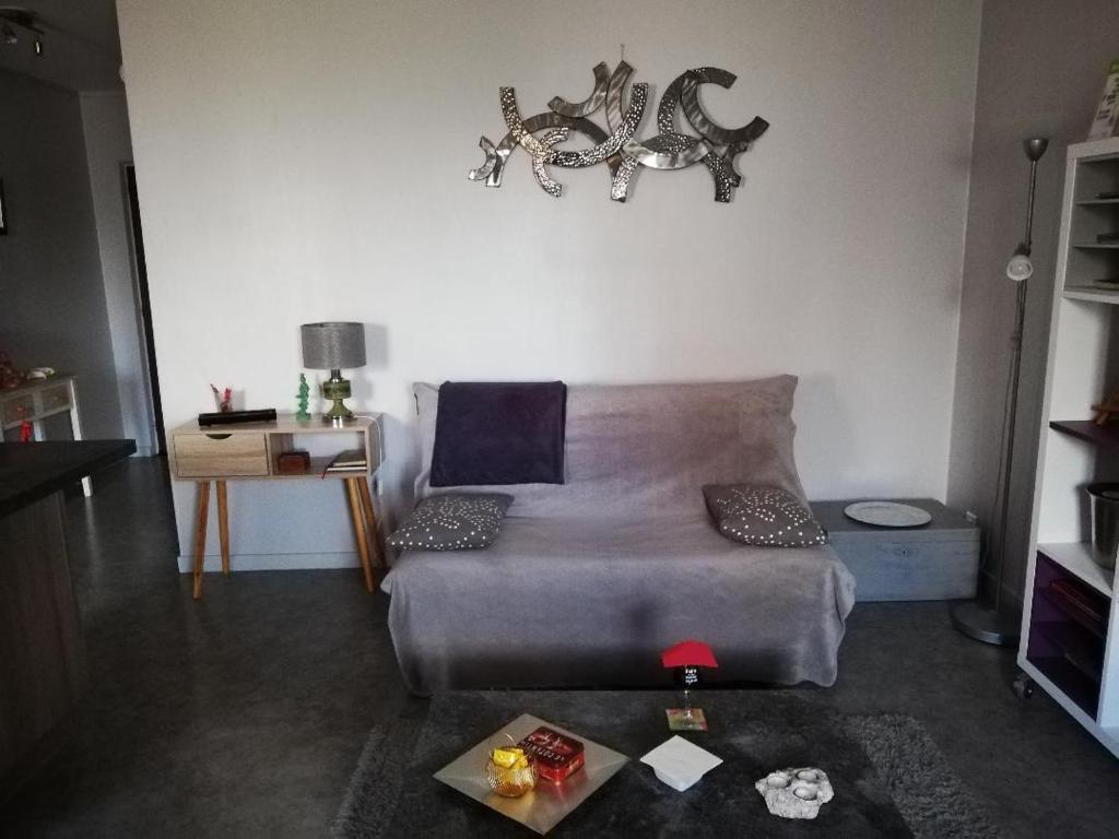 een woonkamer met een bank en een tafel bij L'Orée du Parc à Belfort in Belfort