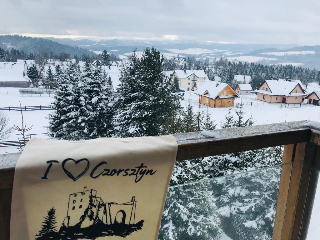 a balcony with a view of a snow covered village at Velo Apartamenty in Czorsztyn