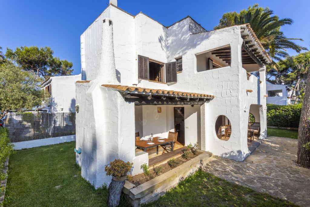 uma casa branca com uma mesa no quintal em Casa Ibicenca Sagitario 454 em Playa de Muro