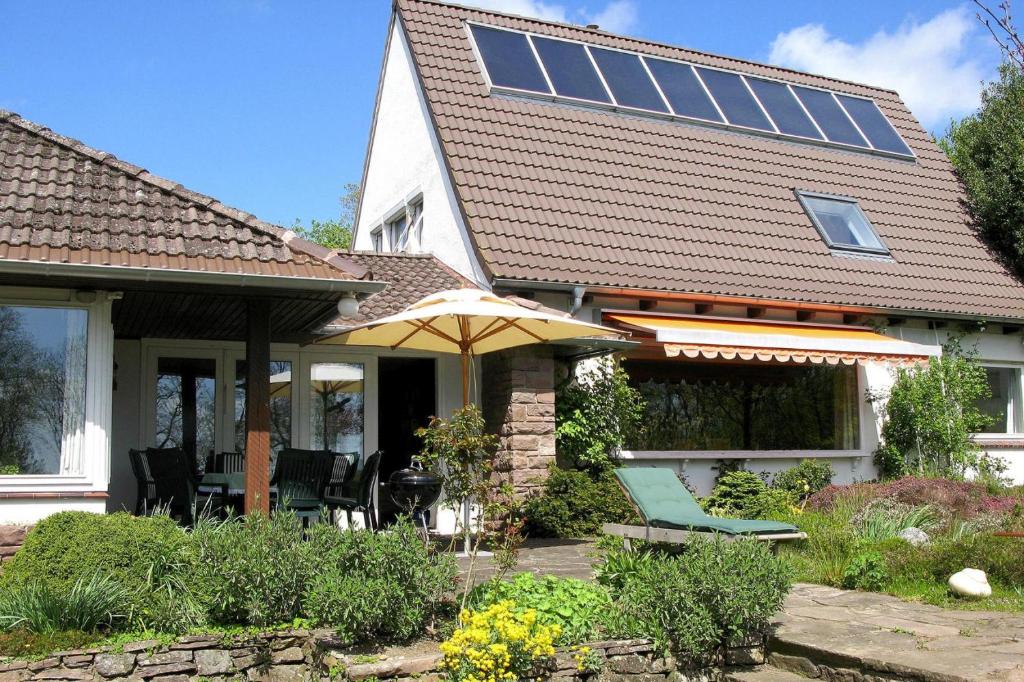 a house with a patio with an umbrella and chairs at Ferienhaus Am Wung, Husum in Husum