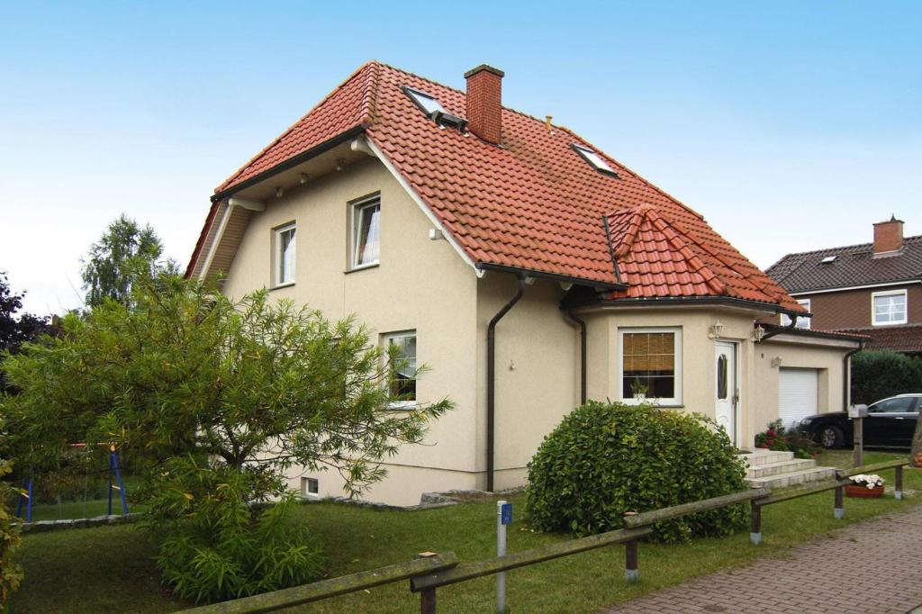una casa blanca con techo naranja en Apartment, Malchow en Malchow