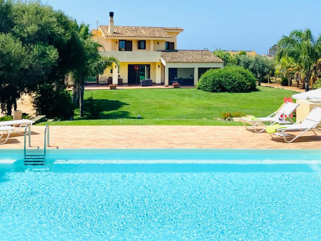 a villa with a swimming pool in front of a house at Villa Laura in Marsala
