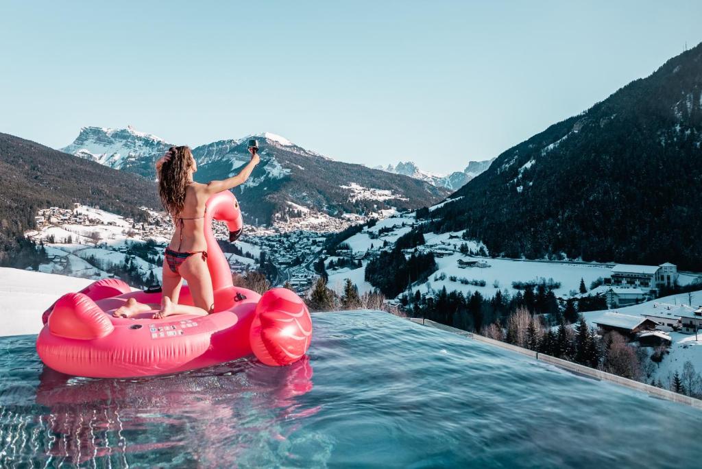 une femme est dans l'eau sur un gonflable dans l'établissement La Cort My Dollhouse - Adults Only, à Ortisei