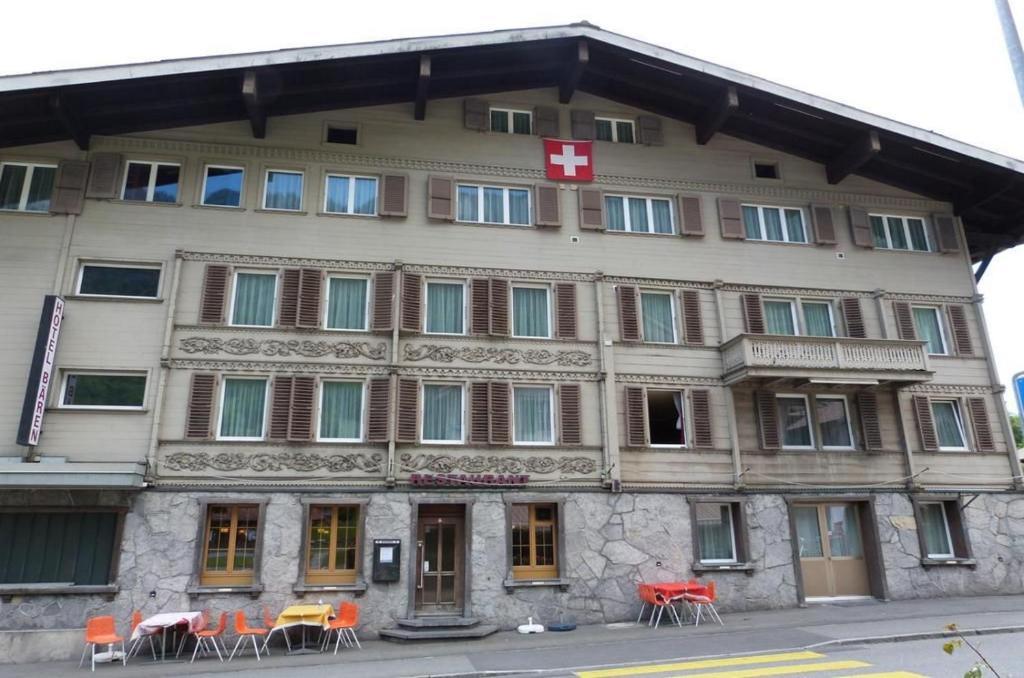 um edifício com cadeiras laranja em frente em Boutique Hotel & Restaurant Bären Ringgenberg em Ringgenberg