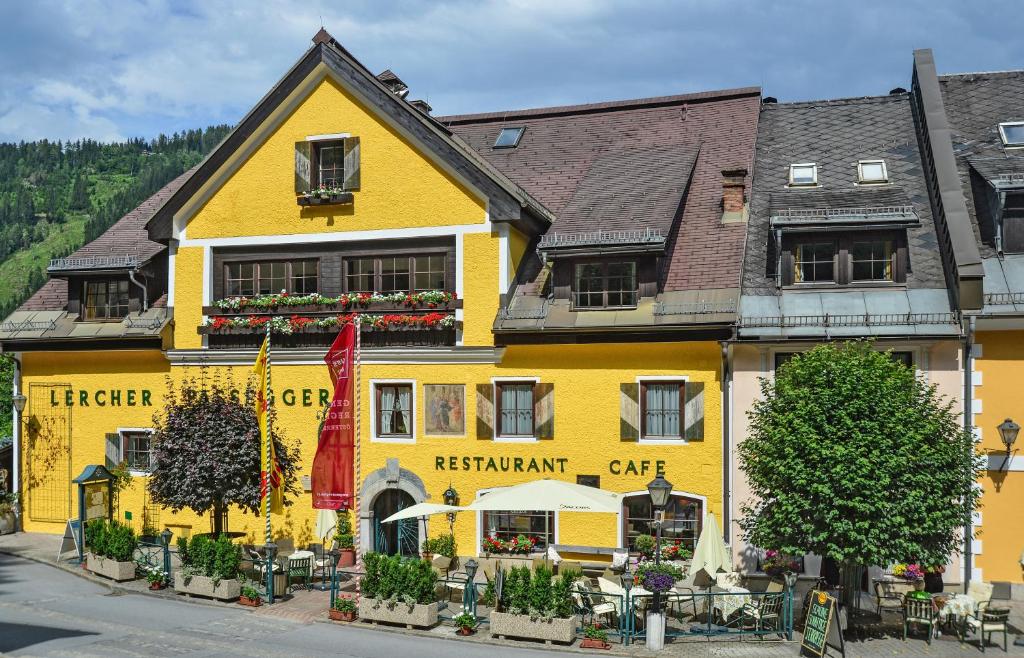 a yellow building with a restaurant on a street at Hotel Gasthof Lercher in Murau