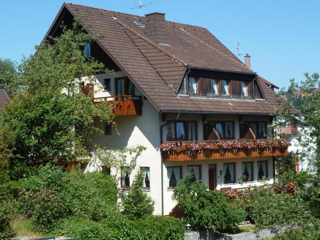Casa blanca con techo marrón en Hotel Rita, en Schonach