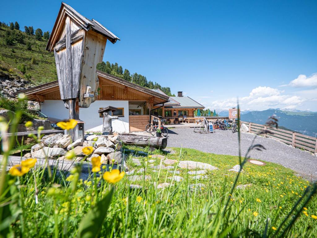 a cabin in the mountains with flowers in front of it at Balbach Alm Apartment in Oetz