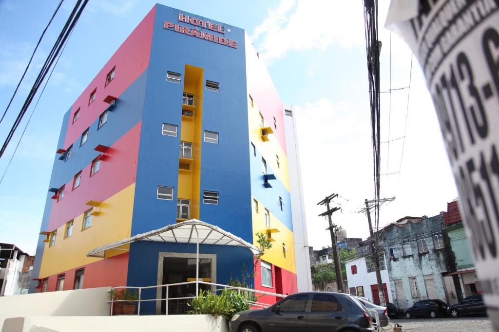 ein farbenfrohes Gebäude mit einem davor geparkt in der Unterkunft Hotel Piramide - Dois de Julho (Adult Only) in Salvador