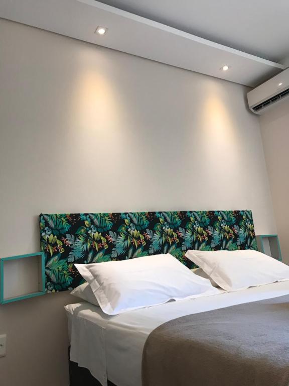 a bedroom with a large bed with white pillows at Ondas da Guarda Moradas in Guarda do Embaú