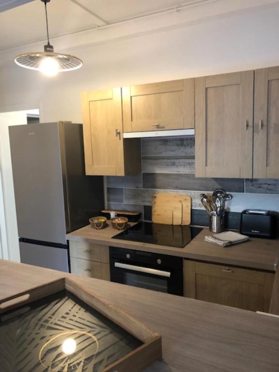 a kitchen with wooden cabinets and a counter top at Hôtel Beau Rivage in Royan