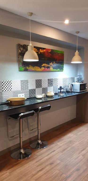 a kitchen with a counter with a bar with stools at Bonito piso en Puerto de Sagunto in Puerto de Sagunto