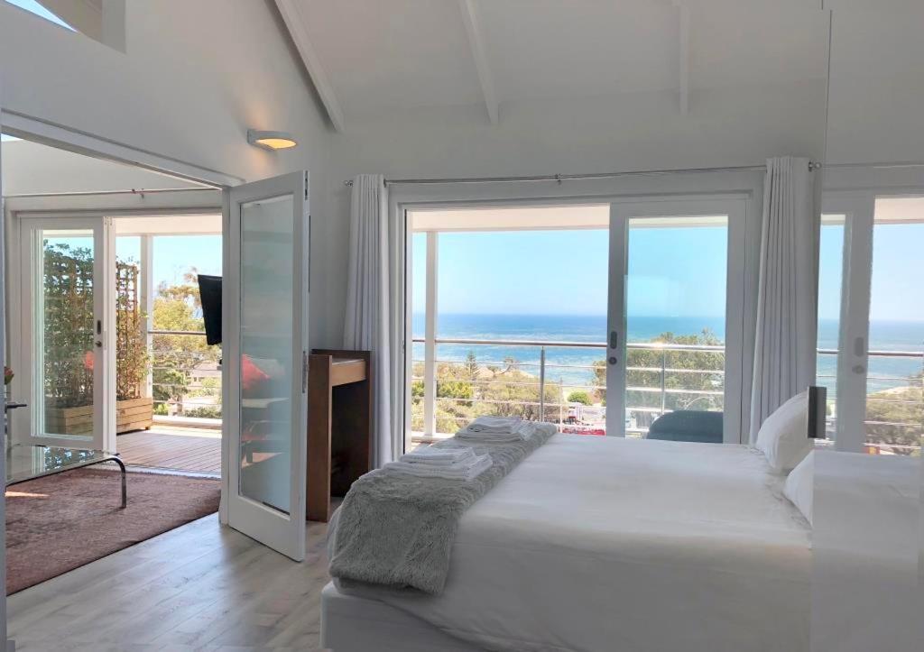 a bedroom with a bed and a view of the ocean at Camps Bay Loft with Stunning Mountain and Ocean Views in Cape Town