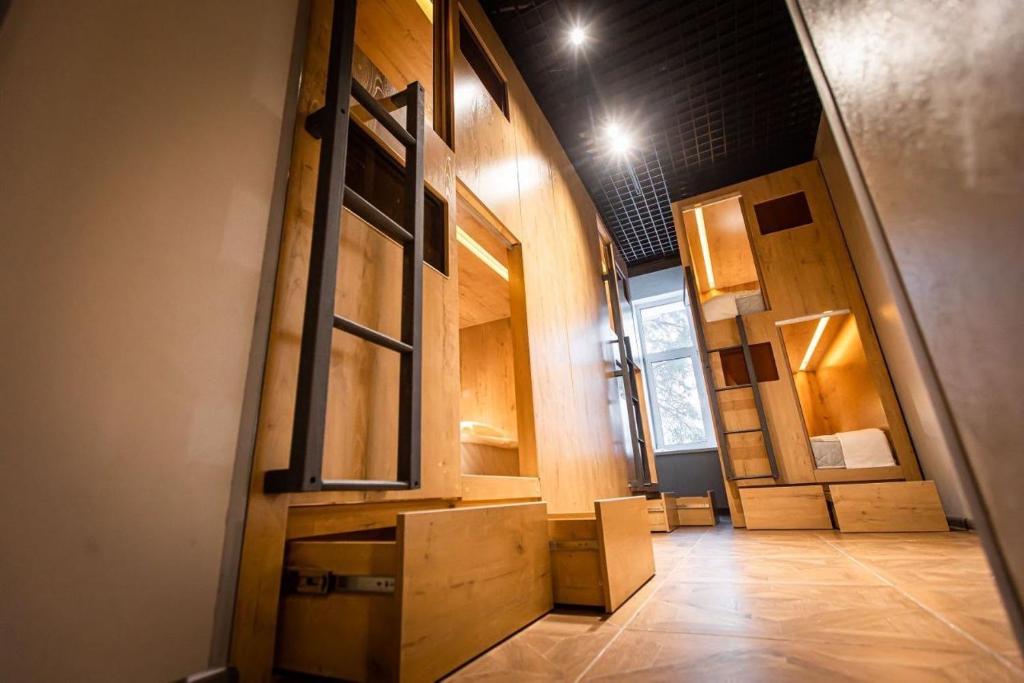 a room with a hallway with wooden cabinets and a floor at CapsLock HOSTEL in Novosibirsk