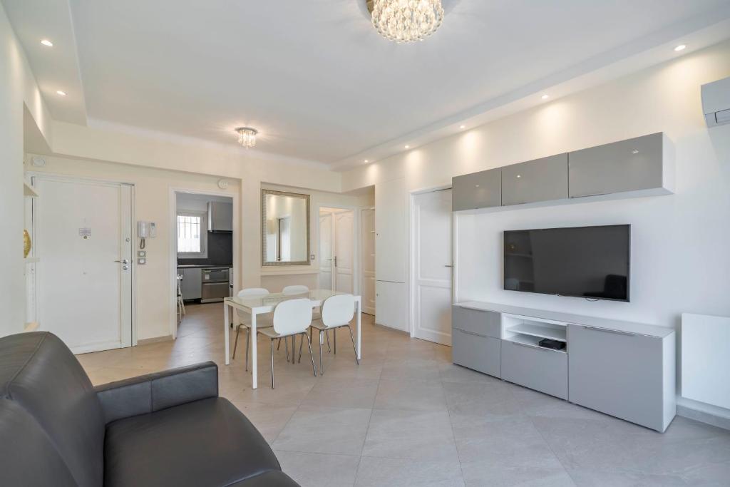 un salon avec un canapé, une télévision et une table dans l'établissement Wdf 2 bedrooms 1min walk to Carlton hotel, à Cannes