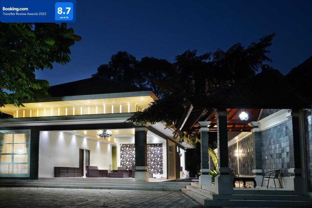 a house with a lit up facade at night at Villa Sanlias in Bogor